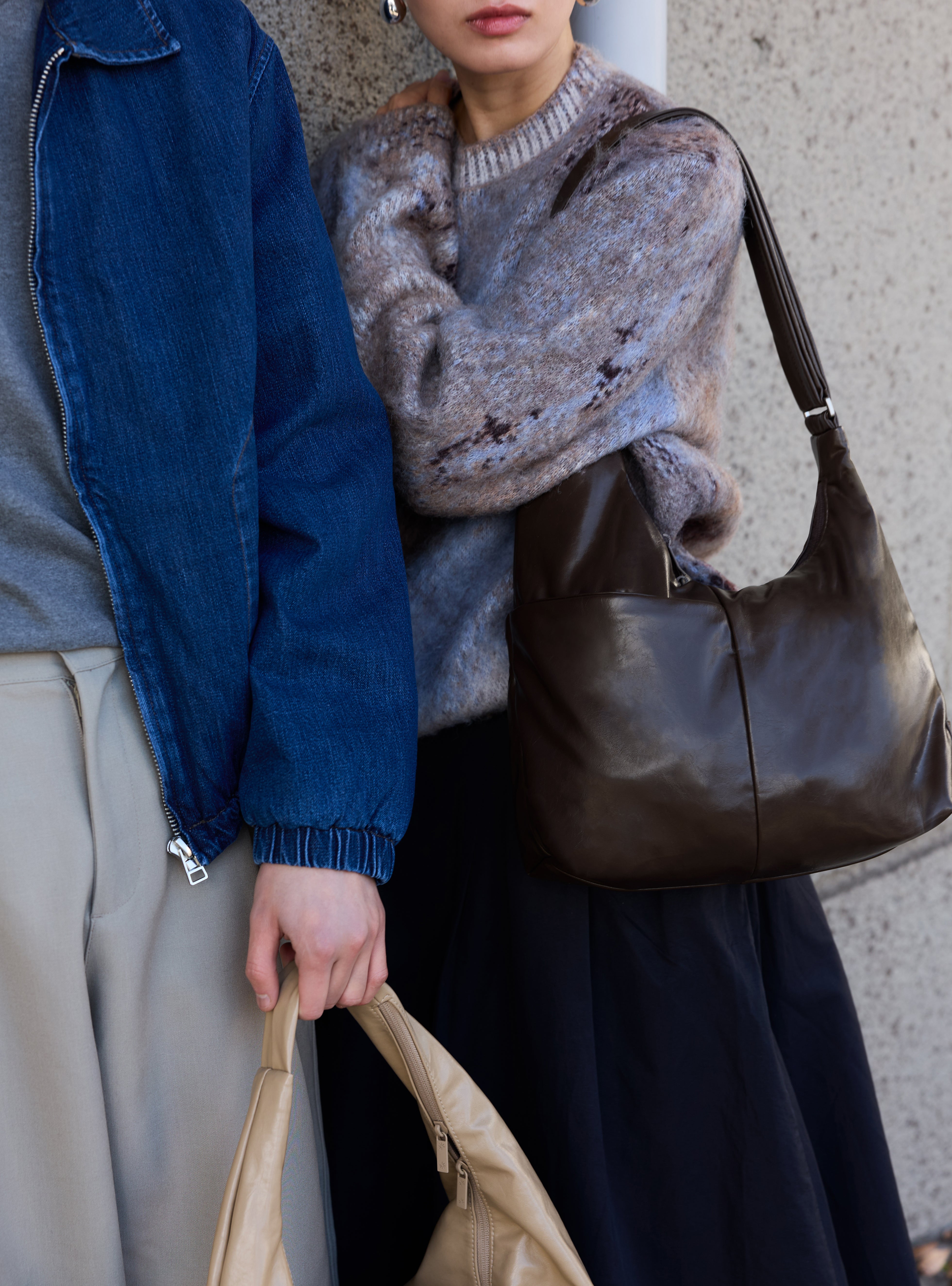 Woman carrying the Midi Arc slouchy hobo bag in dark brown vegan leather as shoulder bag