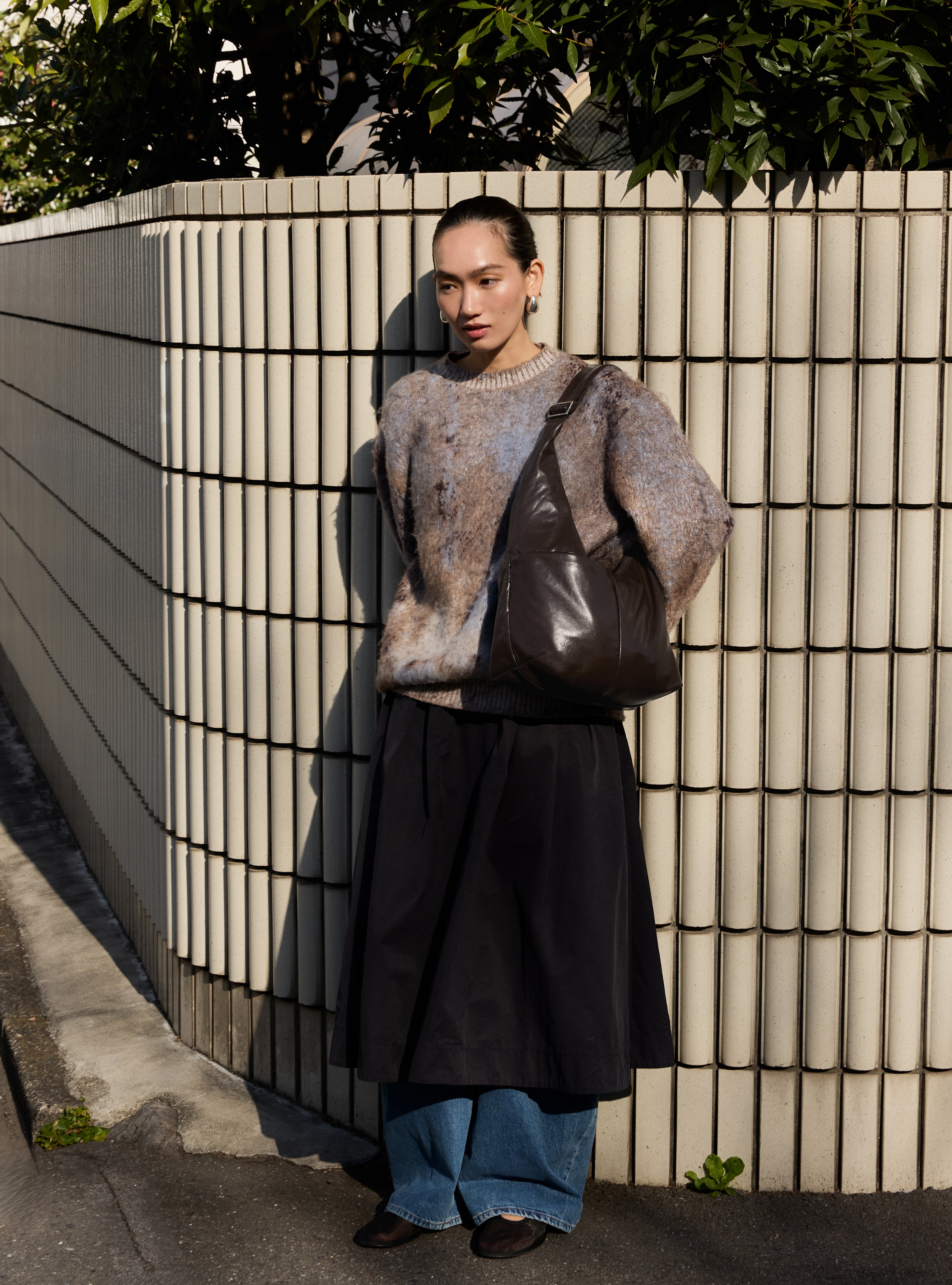 Woman carrying the Midi Arc slouchy hobo bag in dark brown vegan leather as shoulder bag